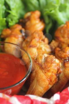 Close up of buffalo wings with barbecue sauce and lettuce for celebration