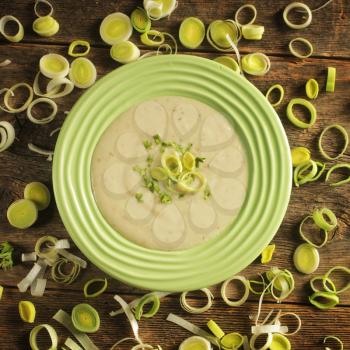 Top view of a bowl of leek soup surrounded by leek rings 