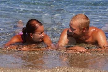 Royalty Free Photo of a Couple Laying in Water Talking