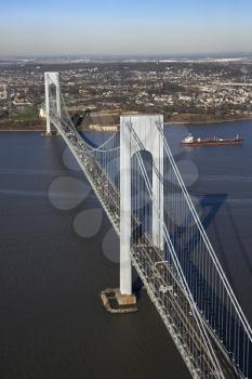 Aerial view of New York City's Verrazano-Narrow's bridge with tanker ship in water.