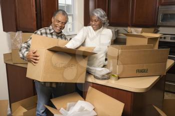 Royalty Free Photo of an Older Couple Packing Moving Boxes in the Kitchen