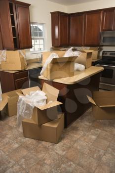 Royalty Free Photo of Cardboard Moving Boxes with Bubble Wrap in the Kitchen