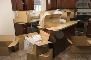 Royalty Free Photo of Cardboard Moving Boxes With Bubble Wrap in a Kitchen