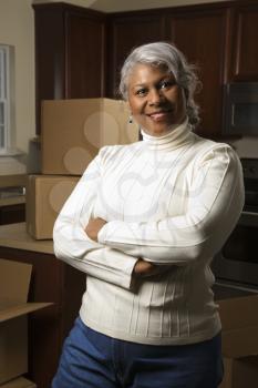 Royalty Free Photo of an Older Female in the Kitchen With Moving Boxes