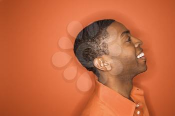 Royalty Free Photo of a Man Smiling Against an Orange Background