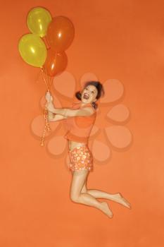 Royalty Free Photo of a Woman Being Lifted into the Air by Balloons