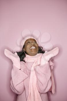 Royalty Free Photo of a Smiling Woman Wearing a Winter Coat, Hat, and Scarf Looking Up