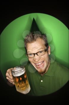 Royalty Free Photo of a Vignette of a Man Wearing a Green Hat and Holding a Beer