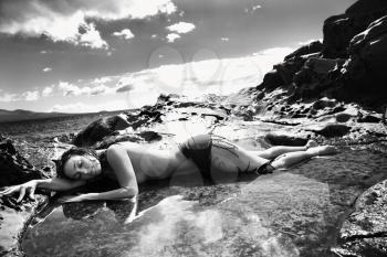 Royalty Free Photo of a Naked Woman Lying in a Tidal Pool at Maui Coast Looking Towards the Ocean