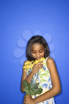Royalty Free Photo of a Teen Girl Smelling a Bouquet of Daisies