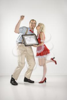 Royalty Free Photo of a Man Cheering and Receiving a Certificate From a Woman