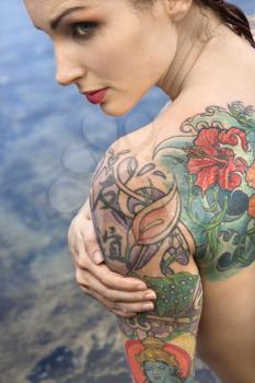 Royalty Free Photo of a Tattooed Woman Standing Over Water