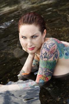 Royalty Free Photo of a Tattooed Woman Lying in a Tidal Pool in Maui, Hawaii, USA