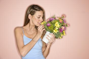 Royalty Free Photo of a Woman Holding a Pot of Flowers