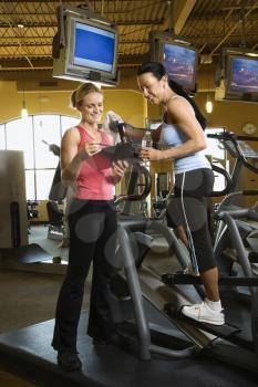 Royalty Free Photo of a Woman on an Elliptical Machine at a Gym With Her Trainer