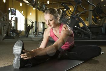 Royalty Free Photo of a Woman Stretching on a Mat in a Gym