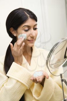 Royalty Free Photo of a Woman Applying Face Scrub in a Mirror