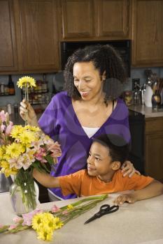 Royalty Free Photo of a Young Pregnant Mother and Son Arranging Flowers