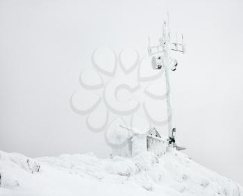 Royalty Free Photo of a Cabin and Antenna Covered in Snow