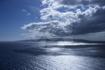 Royalty Free Photo of an Island in Pacific Ocean With Puffy Clouds