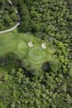 Royalty Free Photo of a Golf Hole on a Golf Course Surrounded by Trees in Maui, Hawaii