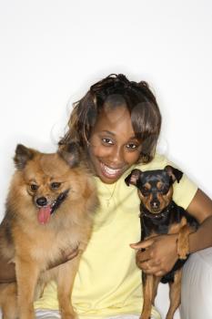 Royalty Free Photo of a Young Female Holding a Pomeranian and Miniature Pinscher Dogs