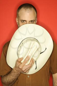 Royalty Free Photo of a Man Peering Over a Cowboy Hat Partially Covering His Face