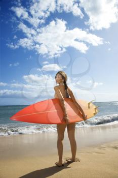 Royalty Free Photo of a Woman in a Bikini Standing With a Surfboard at a Beach in Maui Hawaii