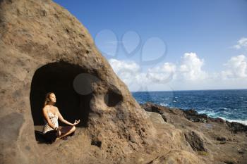 Royalty Free Photo of a Woman Meditating in a Cave With a Coastline of Maui, Hawaii