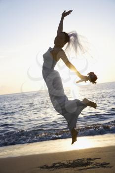 Royalty Free Photo of a Bride Jumping on the Beach