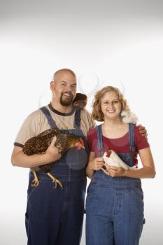 Caucasian mid-adult woman and man with chickens.