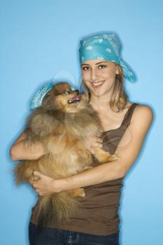 Caucasian teen female holding Pomeranian dog.