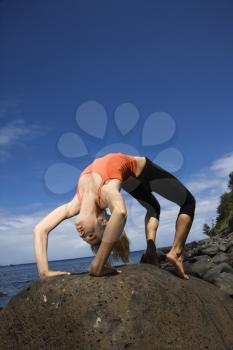 Royalty Free Photo of a Woman Doing Yoga on a Rock
