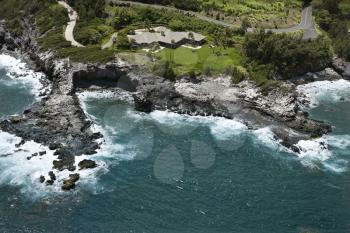 Royalty Free Photo of an Aerial View of Rocky Coastline on Maui, Hawaii With a Rooftop View of Buildings and Roads