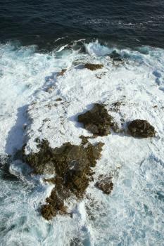 Royalty Free Photo of an Aerial View of Rocks in the Pacific Ocean With Water Swirling Around Them off the Coast of Maui, Hawaii
