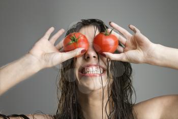 Royalty Free Photo of a Woman Covering Her Eyes With Tomatoes 
