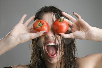 Royalty Free Photo of a Woman Covering Her Eyes With Tomatoes 