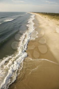 Aerial view of waves crashing on beach on Bald Head Island, North Carolina.