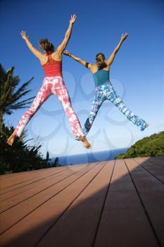 Royalty Free Photo of Women Jumping into the Air With Arms and Legs Outstretched
