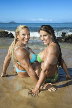 Royalty Free Photo of Female Bodybuilders in Bikinis Sitting in the Sand on Maui Beach