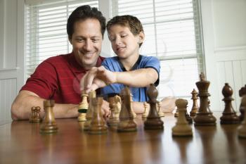Royalty Free Photo of a Father Teaching Chess to His Son