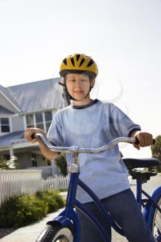 Royalty Free Photo of a Pre-Teen Boy on a Bicycle Wearing a Helmet Smiling
