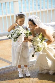 Royalty Free Photo of a Bride Kneeling Next to a Flower Girl