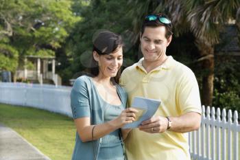 Royalty Free Photo of a Couple Holding a Map and Smiling