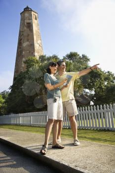 Royalty Free Photo of a Couple Sightseeing With a Lighthouse in the Background at Bald Head Island, North Carolina