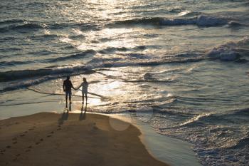Royalty Free Photo of a Couple Holding Hands on a Beach in Bald Head Island, North Carolina at Sunset
