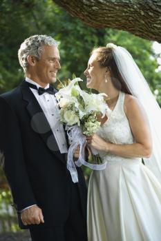 Royalty Free Photo of a Bride and Groom Smiling at One Another Outside