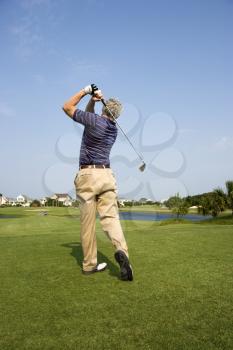 Royalty Free Photo of a Man Swinging a Golf Club