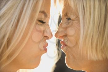 Royalty Free Photo of a Mother and Daughter Face to Face Squinting at Each Other
