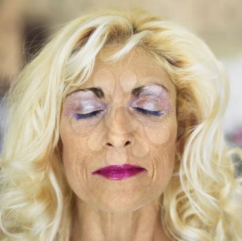 Royalty Free Photo of a Tan Blonde Middle-Aged Woman Wearing Lots of Makeup with Eyes Closed